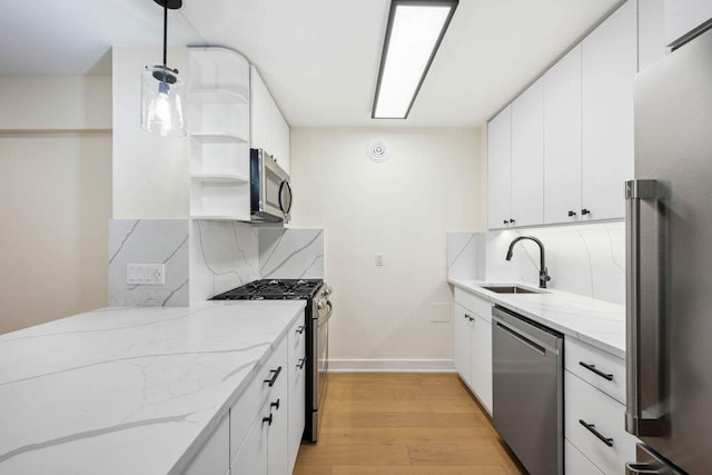 kitchen featuring white cabinetry, appliances with stainless steel finishes, sink, and pendant lighting