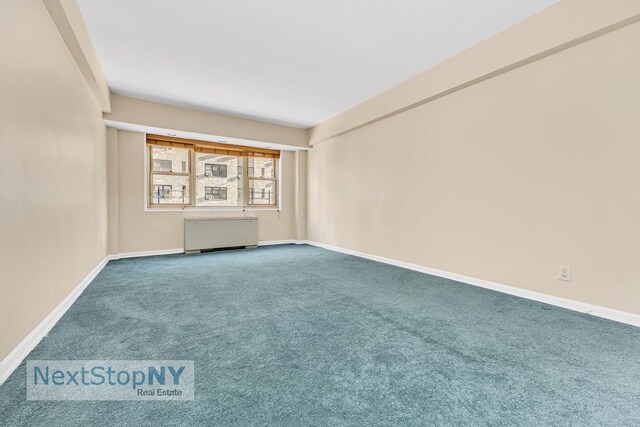 carpeted empty room with baseboards and radiator