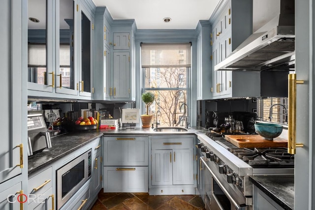 kitchen with wall chimney range hood, sink, appliances with stainless steel finishes, dark stone countertops, and tasteful backsplash