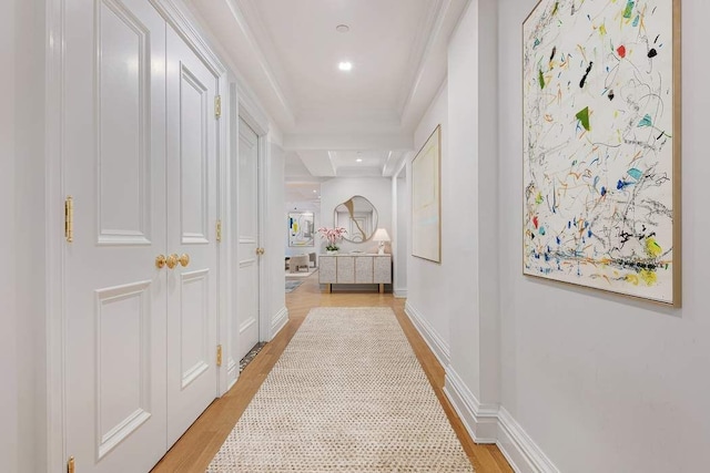 corridor featuring ornamental molding and light hardwood / wood-style flooring