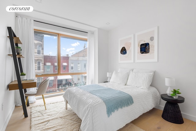 bedroom with visible vents, baseboards, and wood finished floors