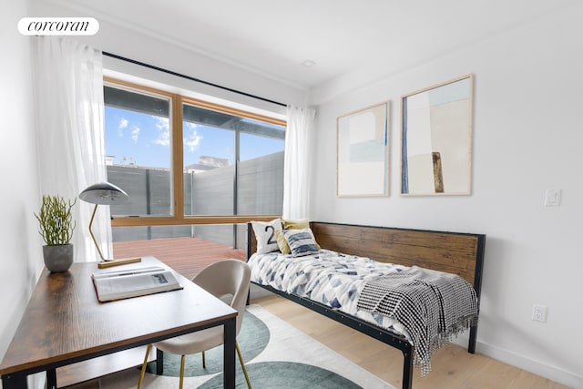 bedroom with baseboards and wood finished floors