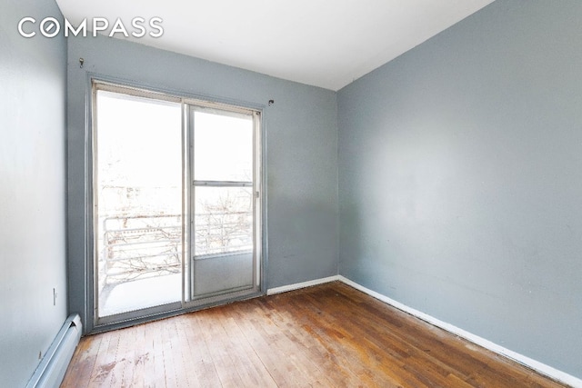 empty room featuring a baseboard radiator and wood-type flooring