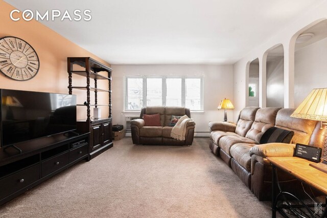 unfurnished room featuring wood-type flooring, a baseboard heating unit, and a wealth of natural light