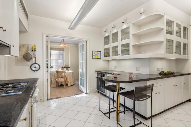 kitchen with stainless steel gas stovetop, white cabinets, and light tile patterned flooring