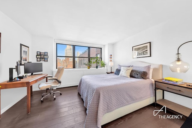 bedroom with dark wood-style floors and baseboards