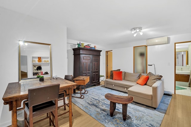 living room featuring an AC wall unit and light wood finished floors