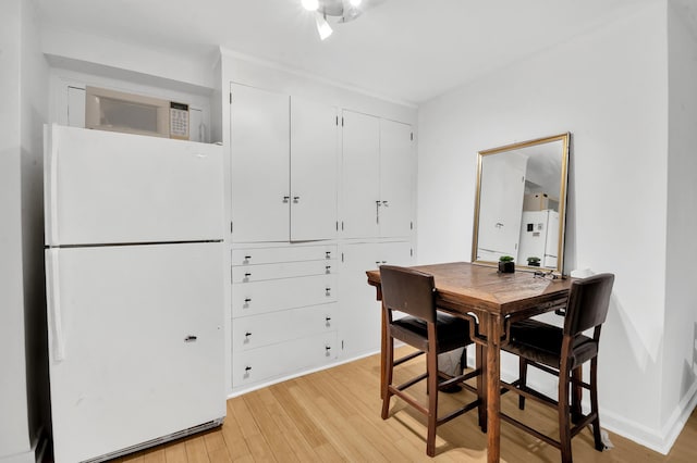 dining area featuring light wood-style floors and baseboards