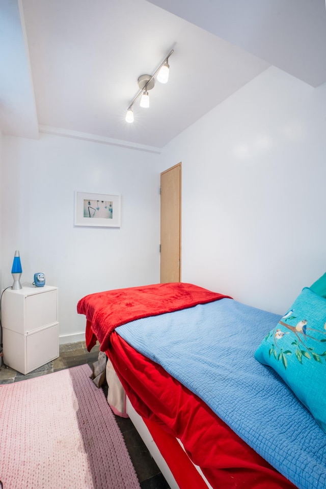 bedroom with rail lighting and baseboards