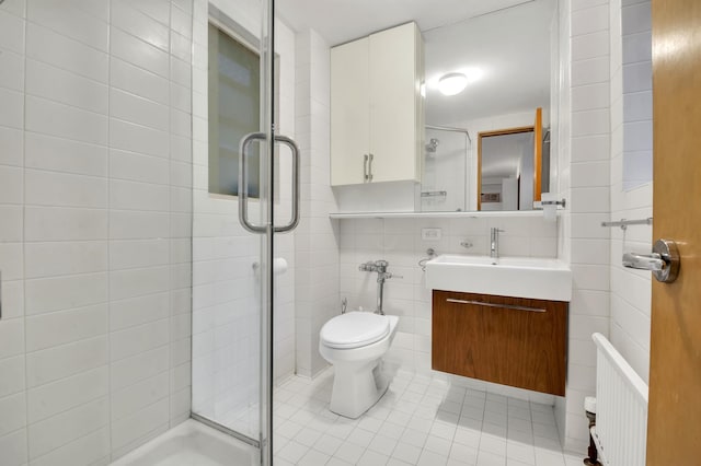 full bathroom with vanity, tile patterned flooring, a shower stall, and tile walls