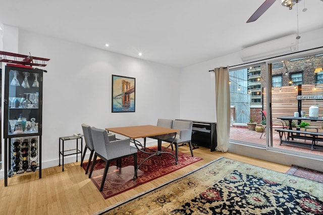 dining room with ceiling fan, recessed lighting, wood finished floors, baseboards, and an AC wall unit