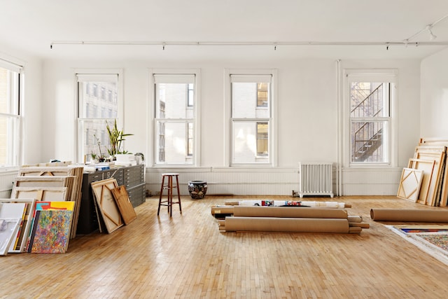 interior details featuring radiator and hardwood / wood-style floors