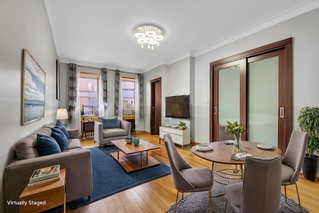 living area featuring light wood-type flooring and crown molding