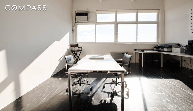 office with dark hardwood / wood-style flooring and a wall mounted air conditioner