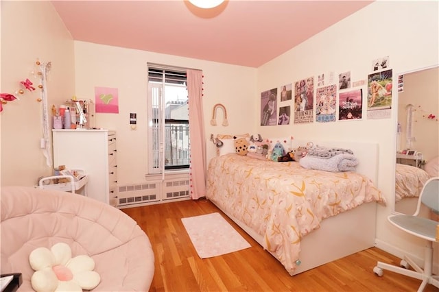 bedroom with access to exterior and wood finished floors