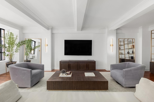 living area with wood finished floors, beam ceiling, and baseboards