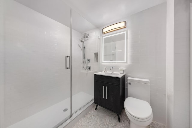 full bath with toilet, tile walls, a stall shower, and vanity