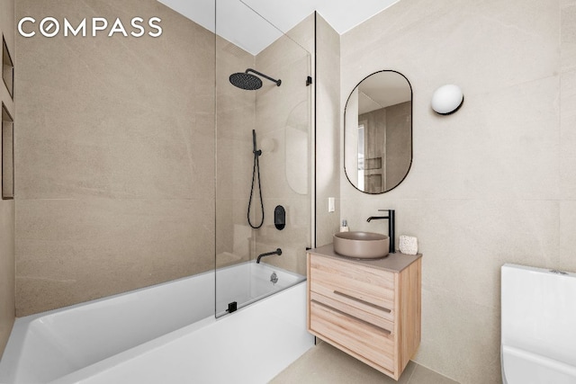 bathroom featuring tile walls, shower / bath combination, and vanity