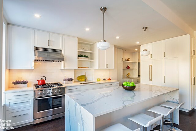 kitchen with pendant lighting, wine cooler, light stone countertops, white cabinets, and a kitchen island