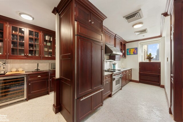 kitchen with sink, crown molding, tasteful backsplash, stainless steel range, and beverage cooler