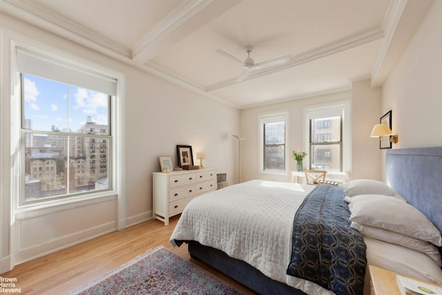 bedroom with beamed ceiling, crown molding, ceiling fan, and light wood-type flooring