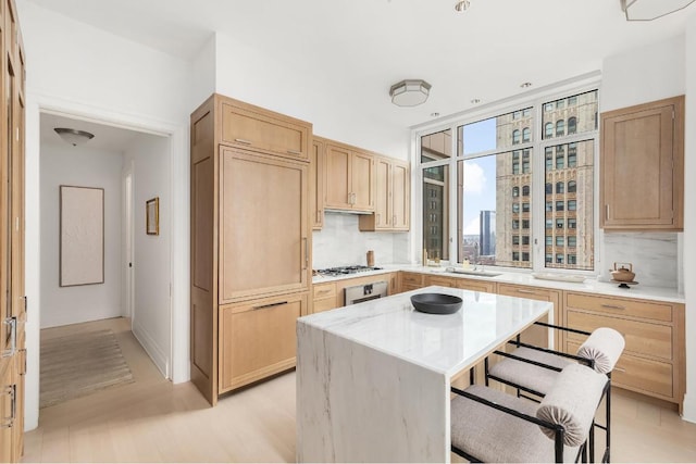 kitchen featuring tasteful backsplash, a breakfast bar area, sink, and a kitchen island