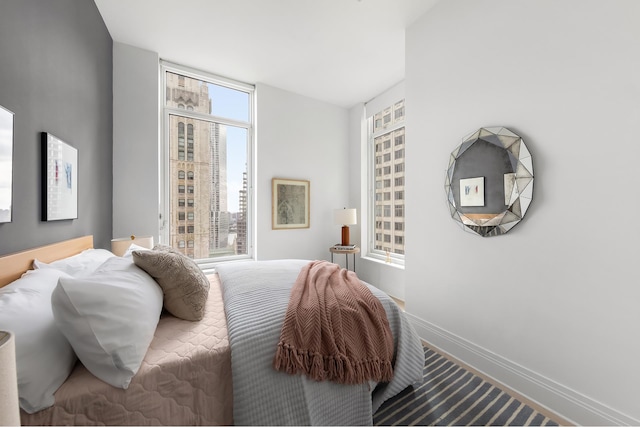 bedroom with carpet floors, multiple windows, and baseboards