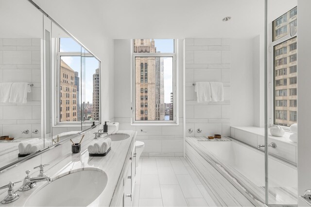 full bathroom with a tub, a sink, tile walls, and a city view