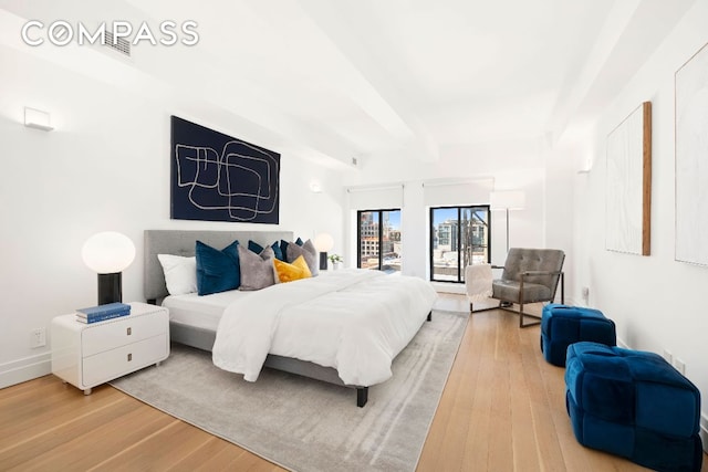 bedroom with wood-type flooring and beamed ceiling