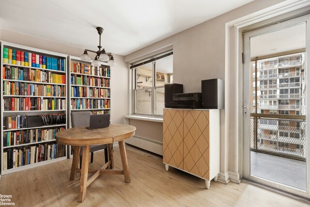 office featuring a baseboard heating unit, hardwood / wood-style flooring, and a notable chandelier