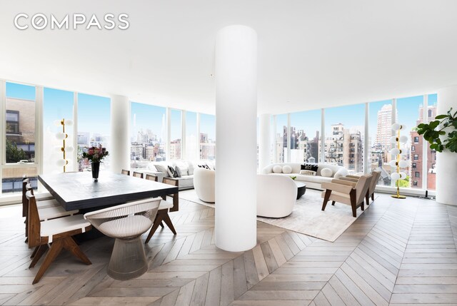 dining room with light parquet flooring, a wealth of natural light, and a wall of windows