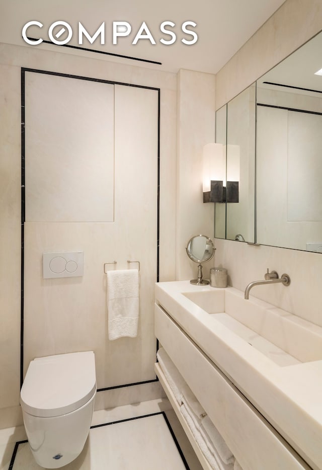 half bathroom with toilet, tile patterned floors, and vanity