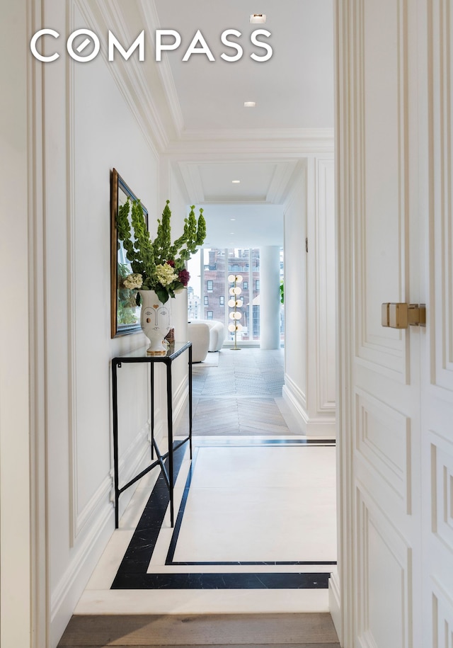 hallway featuring ornamental molding and baseboards