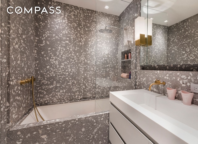 full bath with a tub with marble appearance, walk in shower, and vanity