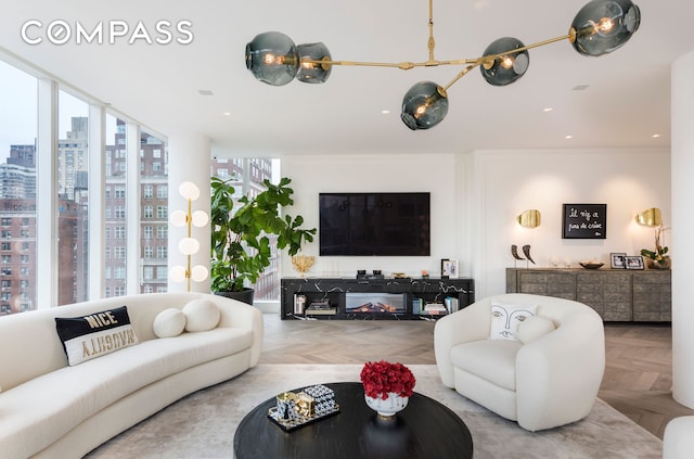 living room with a view of city, a healthy amount of sunlight, crown molding, and recessed lighting
