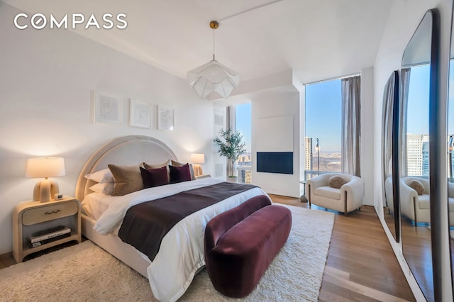 bedroom with wood finished floors and expansive windows