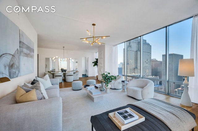 living area with expansive windows, a city view, wood finished floors, and an inviting chandelier