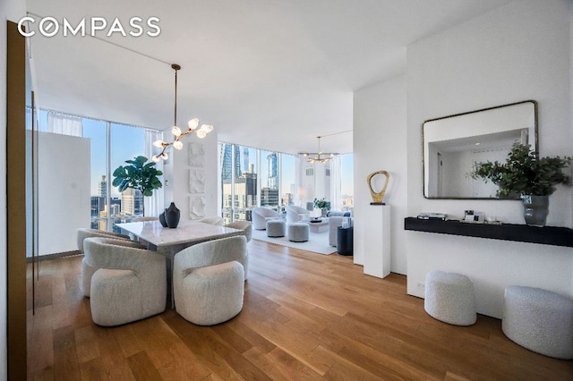 living room with an inviting chandelier, expansive windows, and hardwood / wood-style floors