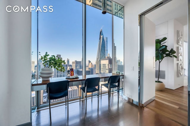 dining room with expansive windows, a city view, and wood finished floors