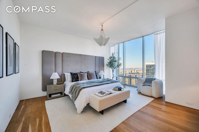 bedroom with wood finished floors and expansive windows