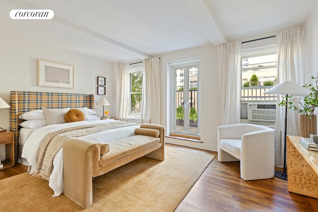 bedroom featuring dark hardwood / wood-style floors, access to outside, beam ceiling, and cooling unit