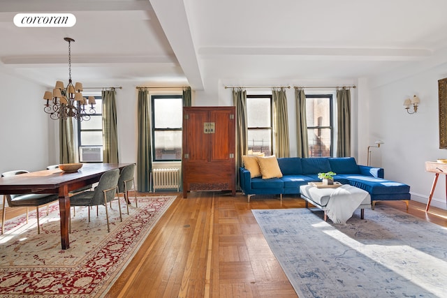 living area featuring visible vents, baseboards, radiator heating unit, beamed ceiling, and a notable chandelier