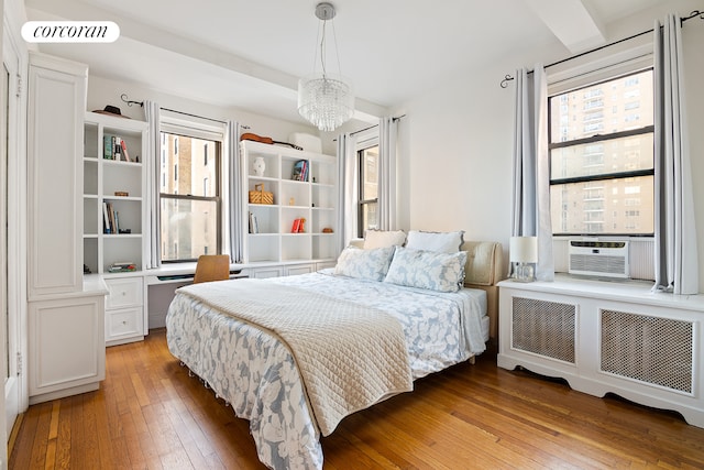 18 W 70th St Unit 8C, New York City, NY 10023 - bedroom with radiator heating unit, light wood-style flooring, a chandelier, and cooling unit