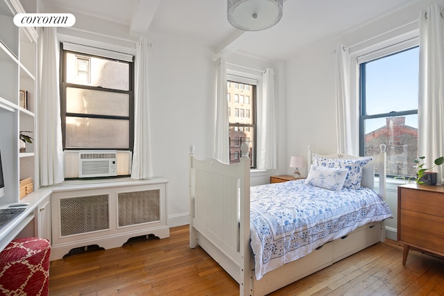 18 W 70th St Unit 8C, New York City, NY 10023 - bedroom with light wood finished floors, cooling unit, and radiator
