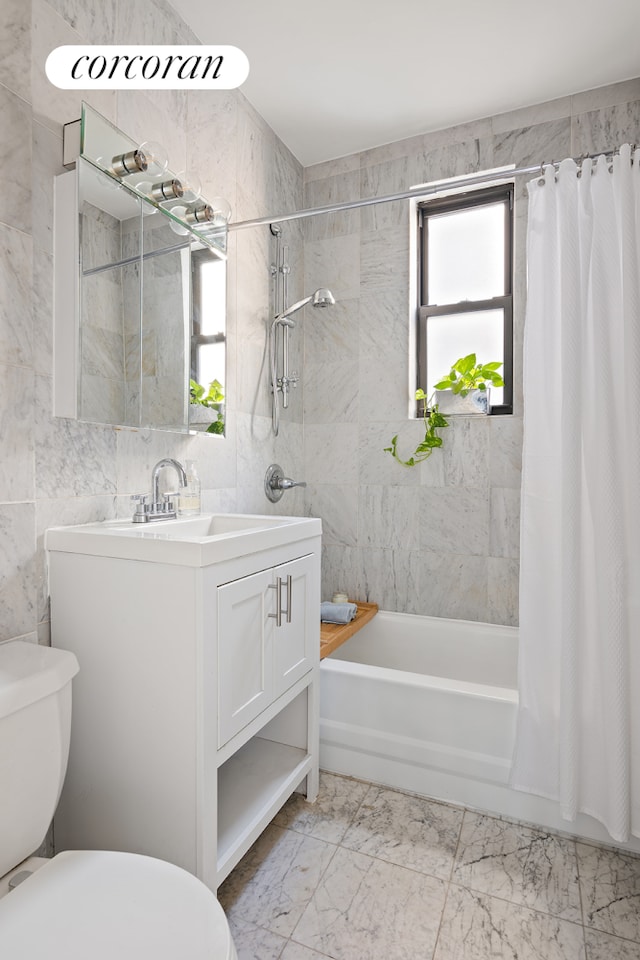 18 W 70th St Unit 8C, New York City, NY 10023 - full bathroom with toilet, shower / tub combo with curtain, vanity, tile walls, and marble look tiles
