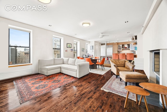 living area with ceiling fan and wood finished floors