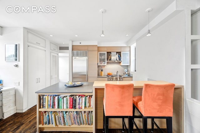 kitchen with ventilation hood, stainless steel built in fridge, decorative light fixtures, and dark wood-style flooring