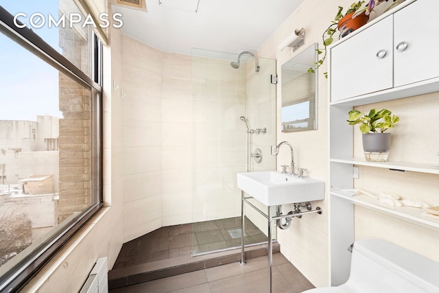 full bathroom featuring visible vents, toilet, tile patterned floors, a sink, and a tile shower