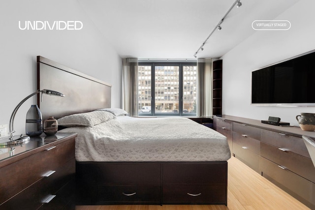 303 E 33rd St Unit 3G, New York City, NY 10016 - bedroom featuring rail lighting and light wood-type flooring