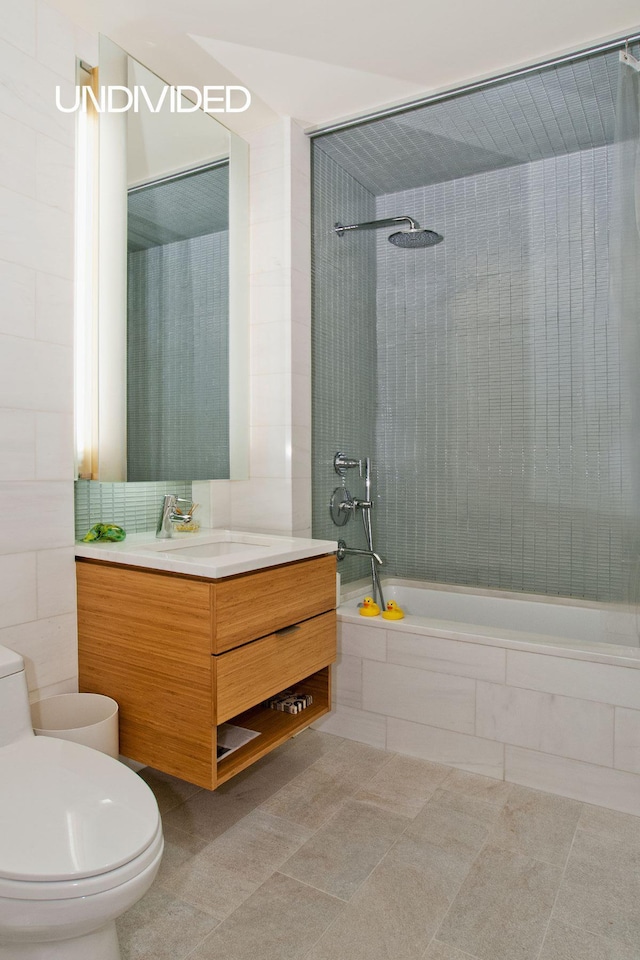 303 E 33rd St Unit 3G, New York City, NY 10016 - bathroom with toilet, tiled shower / bath, vanity, tile patterned flooring, and tile walls